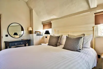 a bedroom with a white bed and a mirror at The Woolpack Inn in Coggeshall
