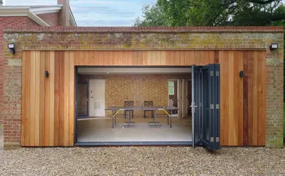 an open garage with a table inside of it at Garden House at Woodhall Estate in Hertford