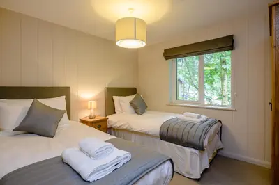 a bedroom with two beds and a window at Woolverstone Marina and Lodge Park in Ipswich