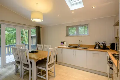a kitchen and dining room with a table and chairs at Woolverstone Marina and Lodge Park in Ipswich