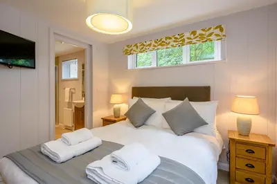 a bedroom with a large white bed with two pillows at Woolverstone Marina and Lodge Park in Ipswich