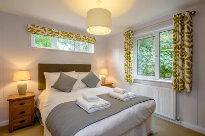 a bedroom with a bed with two towels on it at Woolverstone Marina and Lodge Park in Ipswich