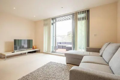a living room with a couch and a flat screen tv at 2 BR flat next to Train Station & Gated Parking in Cambridge