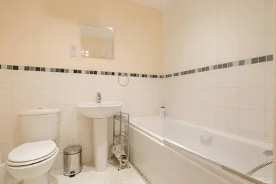 a bathroom with a toilet and a sink and a tub at 2 BR flat next to Train Station & Gated Parking in Cambridge