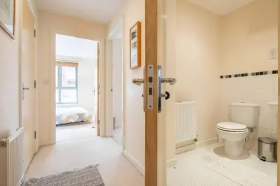 a bathroom with a toilet and a bedroom at 2 BR flat next to Train Station & Gated Parking in Cambridge
