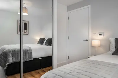 a bedroom with two beds and a closet at Citystay Living - Dutch's Corner in Cambridge