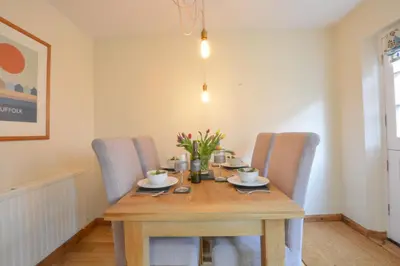 a dining room with a wooden table and chairs at Chapel Cottage, Newbourne in Newbourn