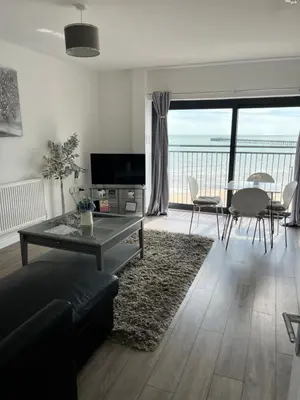 a living room with a couch and a table at Penthouse Apartment with seaviews in Walton-on-the-Naze