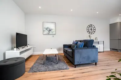 a living room with a blue couch and a tv at Citystay Living - Holland Place in Cambridge