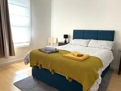 a bedroom with a bed with a yellow blanket on it at 300m to Fitzwilliam museum 3 en-suites double bedroom Victoria house in Cambridge