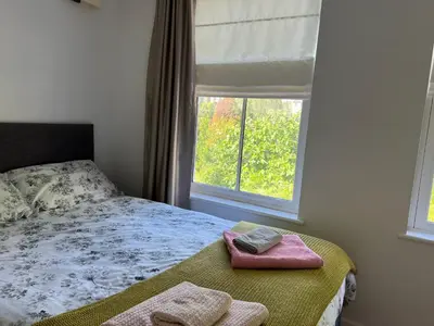 a bedroom with a bed with two towels and a window at 300m to Fitzwilliam museum 3 en-suites double bedroom Victoria house in Cambridge