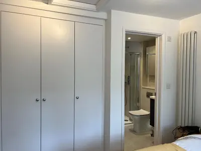 a bedroom with white cabinets and a bathroom with a toilet at 300m to Fitzwilliam museum 3 en-suites double bedroom Victoria house in Cambridge