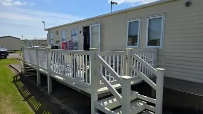 a house with a white deck with a porch at None available in Jaywick Sands