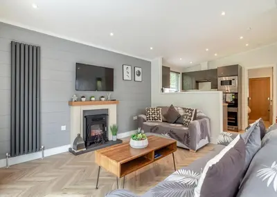 a living room with a couch and a fireplace at The Essex Golf And Country Club in Markshall