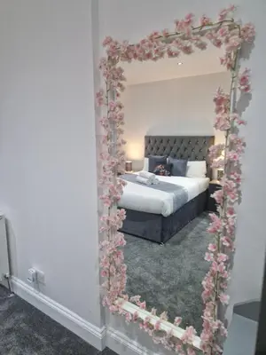 a bedroom with a bed and a mirror with flowers at WNS Southend-on-Sea in Southend-on-Sea