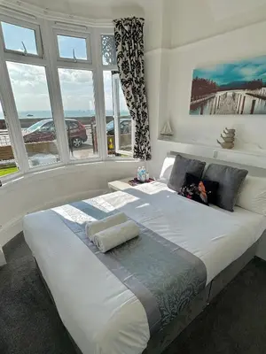 a bedroom with a large white bed with windows at WNS Southend-on-Sea in Southend-on-Sea