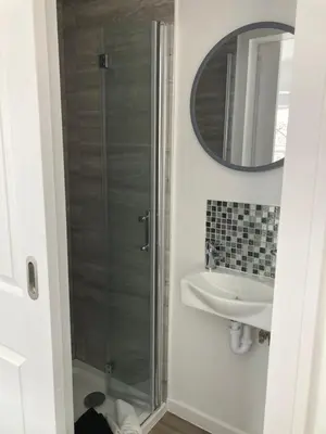 a bathroom with a shower and a sink and a mirror at Kings Lodge in Newmarket