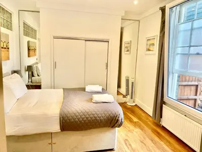a bedroom with a bed and a large window at EMMANUEL HOUSE - Beautiful 1-Bedroom Apt In Central Cambridge - Historical Building in Cambridge
