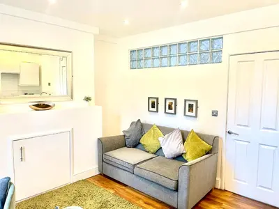 a living room with a couch and a window at EMMANUEL HOUSE - Beautiful 1-Bedroom Apt In Central Cambridge - Historical Building in Cambridge