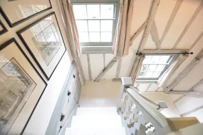 a staircase in a house with windows at The Gig House, Stowupland in Stowmarket