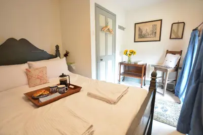 a bedroom with a bed with a tray of food on it at The Gig House, Stowupland in Stowmarket