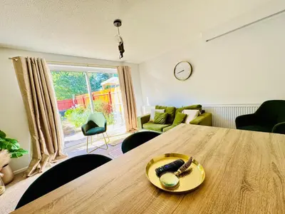 a dining room with a wooden table and chairs at The Jade House - Cambridge Rental with Garden and BBQ, Near City Centre in Cambridge