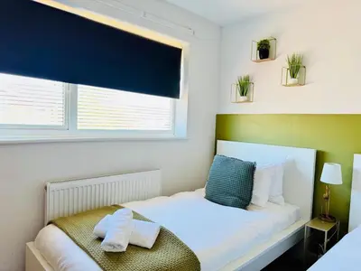 a small bedroom with a bed and a window at The Jade House - Cambridge Rental with Garden and BBQ, Near City Centre in Cambridge