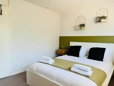 a bedroom with a white bed with towels on it at The Jade House - Cambridge Rental with Garden and BBQ, Near City Centre in Cambridge