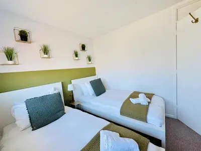 a small room with two beds and a couch at The Jade House - Cambridge Rental with Garden and BBQ, Near City Centre in Cambridge