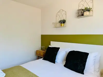 a bedroom with a bed and two plants on the wall at The Jade House - Cambridge Rental with Garden and BBQ, Near City Centre in Cambridge