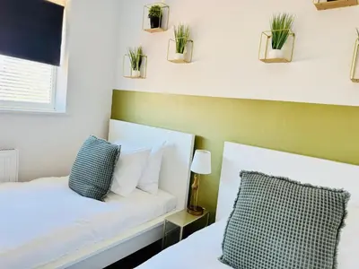 a bedroom with a bed with plants on the wall at The Jade House - Cambridge Rental with Garden and BBQ, Near City Centre in Cambridge