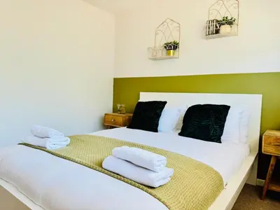 a bedroom with a white bed with towels on it at The Jade House - Cambridge Rental with Garden and BBQ, Near City Centre in Cambridge