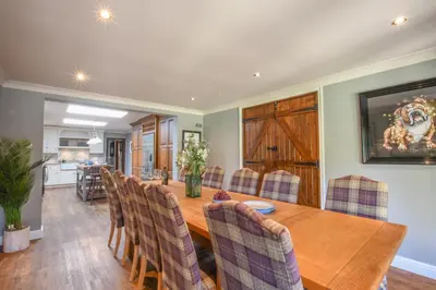 a dining room with a wooden table and chairs at Moat Barn in Debach