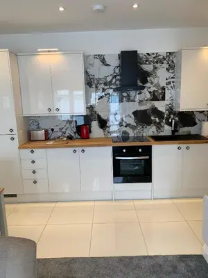 a kitchen with white cabinets and a stove at The old forge in Graveley