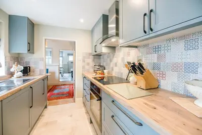 a kitchen with blue cabinets and a counter top at Periwinkle Cottage, Aldeburgh in Aldeburgh