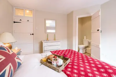 a bedroom with a tray of food on a bed at Periwinkle Cottage, Aldeburgh in Aldeburgh