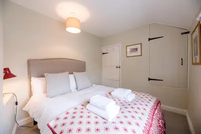 a bedroom with a bed with two towels on it at Periwinkle Cottage, Aldeburgh in Aldeburgh