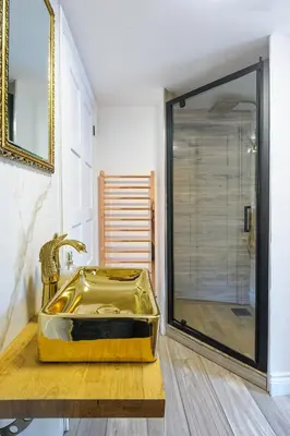 a bathroom with a gold sink and a shower at Executive Suite with Private HotTub, Full SkyTV in 600 Year Old Manor House in Saffron Walden