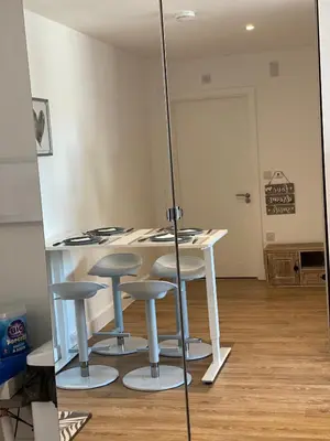 a kitchen with a table and stools in a room at Blanco Uno in Colchester