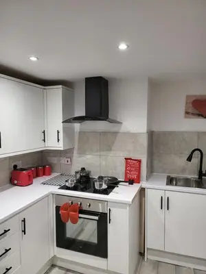 a kitchen with white cabinets and a stove top oven at Colchester House with garden and parking- Sleeps up to 7 - Free Wi-Fi - Contractors - Families - Long Term Stays in Colchester