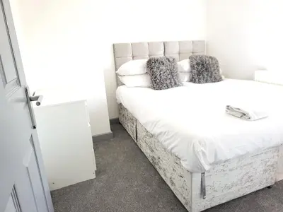a bedroom with a large white bed with pillows at Colchester House with garden and parking- Sleeps up to 7 - Free Wi-Fi - Contractors - Families - Long Term Stays in Colchester