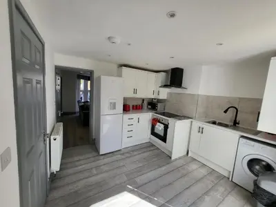 a kitchen with white cabinets and a washer at Colchester House with garden and parking- Sleeps up to 7 - Free Wi-Fi - Contractors - Families - Long Term Stays in Colchester