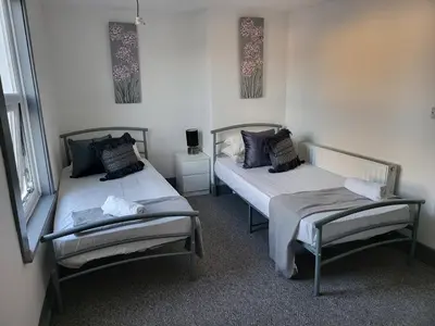a room with two beds and two windows at Colchester House with garden and parking- Sleeps up to 7 - Free Wi-Fi - Contractors - Families - Long Term Stays in Colchester