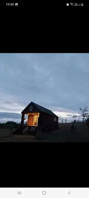 a barn with its lights on in a field at Lake View Lodges The Kentwell in Long Melford