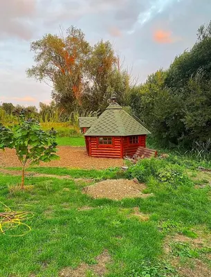 a small red building in the middle of a field at Lake View Lodges The Kentwell in Long Melford