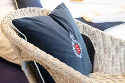 a black pillow sitting on a wicker chair at The Royal Burnham Yacht Club in Burnham on Crouch
