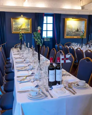 a long table with wine bottles and glasses on it at The Royal Burnham Yacht Club in Burnham on Crouch