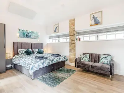a bedroom with a bed and a couch at Peacock On The Pin in Stisted