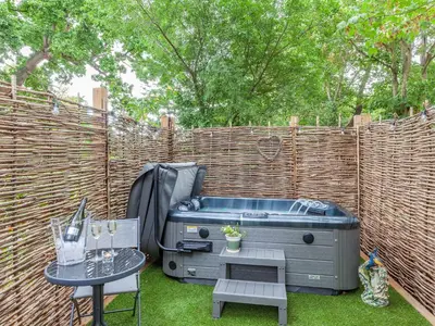 a backyard with a hot tub and a table at Peacock On The Pin in Stisted