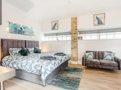 a bedroom with a large bed and a couch at Peacock On The Pin in Stisted